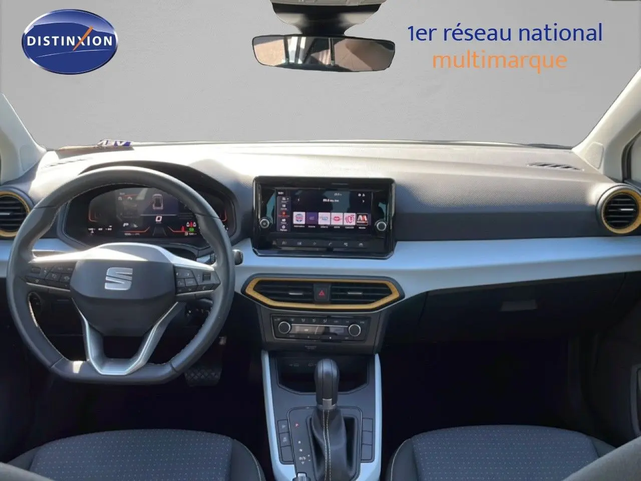 Vue intérieure avant du SEAT Arona 2025, tableau de bord noir avec écran tactile et volant multifonction cuir.