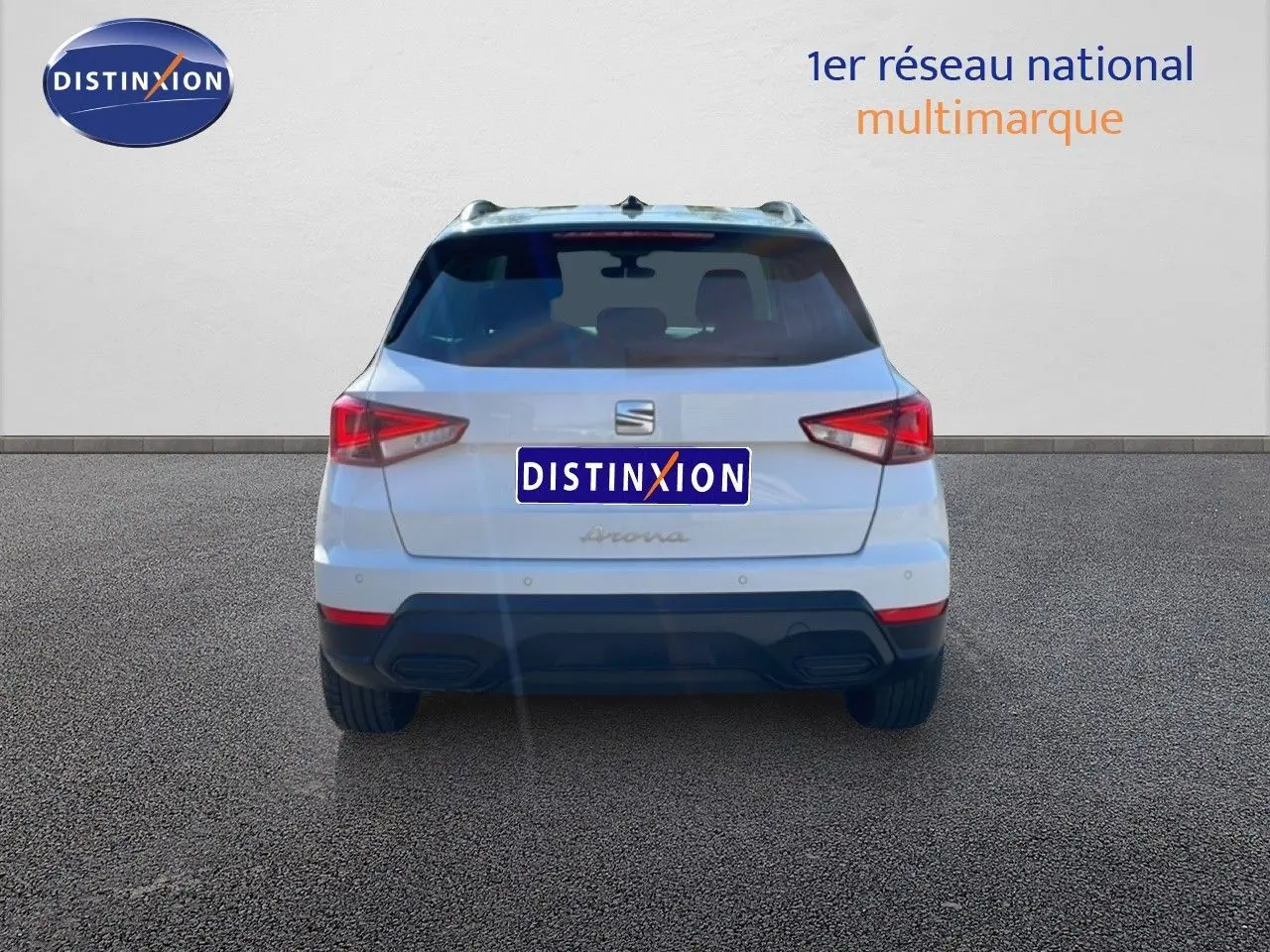 Vue arrière d’un SEAT Arona blanc avec toit gris, mettant en valeur ses feux arrière anguleux et son pare-chocs noir.