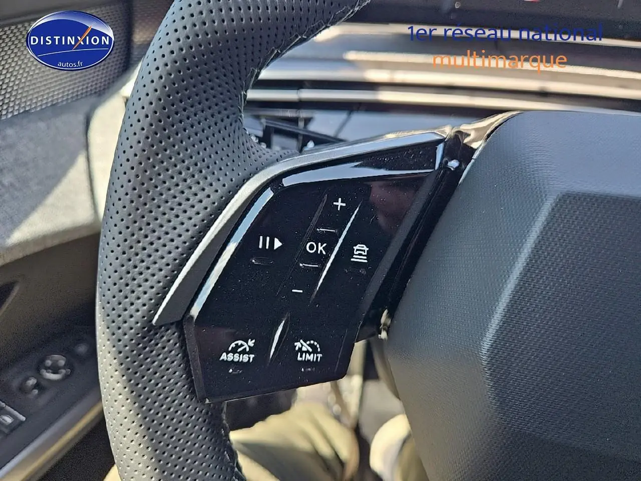 Gros plan sur les commandes multifonctions noires du volant cuir perforé côté gauche d’un Peugeot 3008 noir 2025.