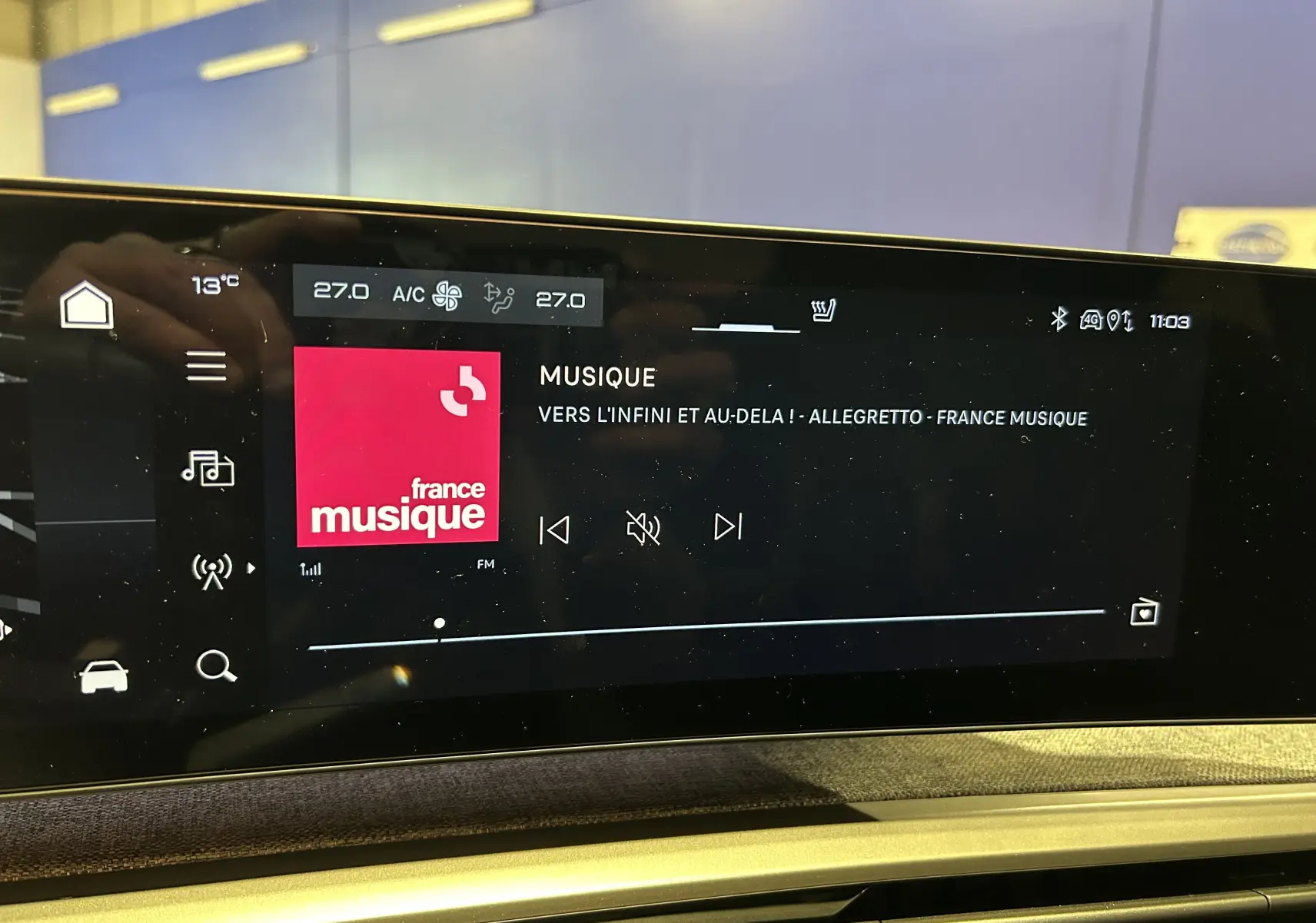 Écran tactile central du tableau de bord du Peugeot 3008 blanc, affichant la radio France Musique et la climatisation à 27°C.