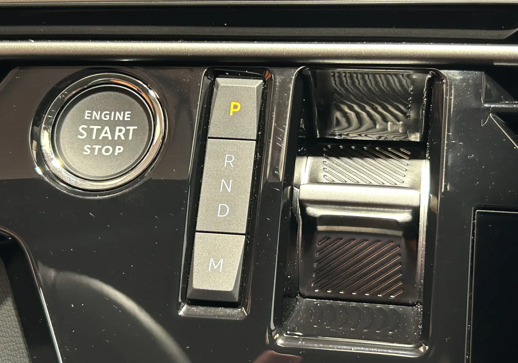 Détail du tableau de bord du Peugeot 3008 III Hybrid 145, montrant le bouton start/stop et la commande de boîte automatique.