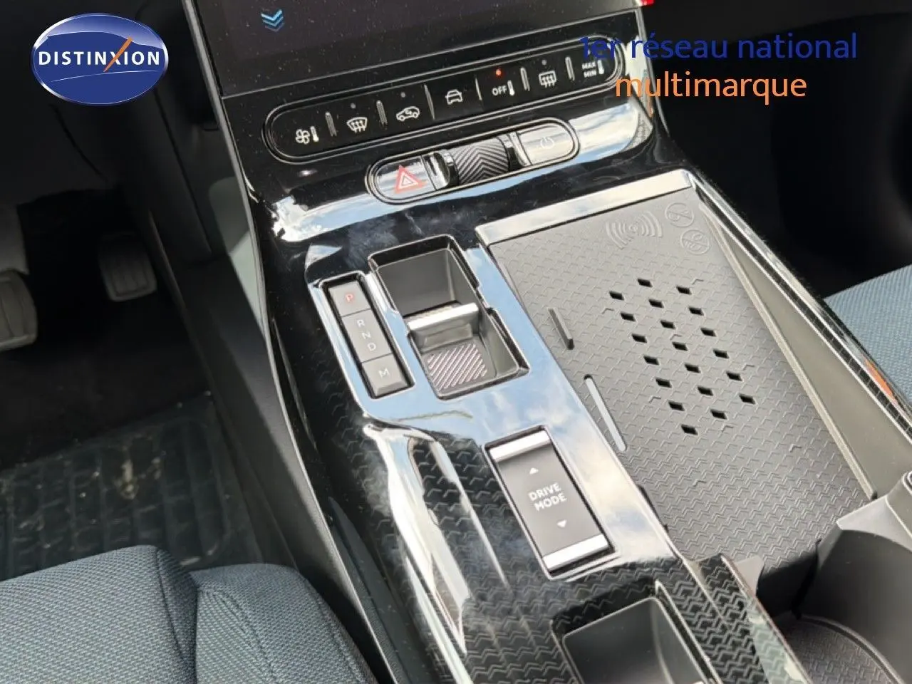 Vue plongeante sur la console centrale noire brillante du Citroën C5 Aircross Hybrid 2026 avec commandes de boîte auto et recharge sans fil.