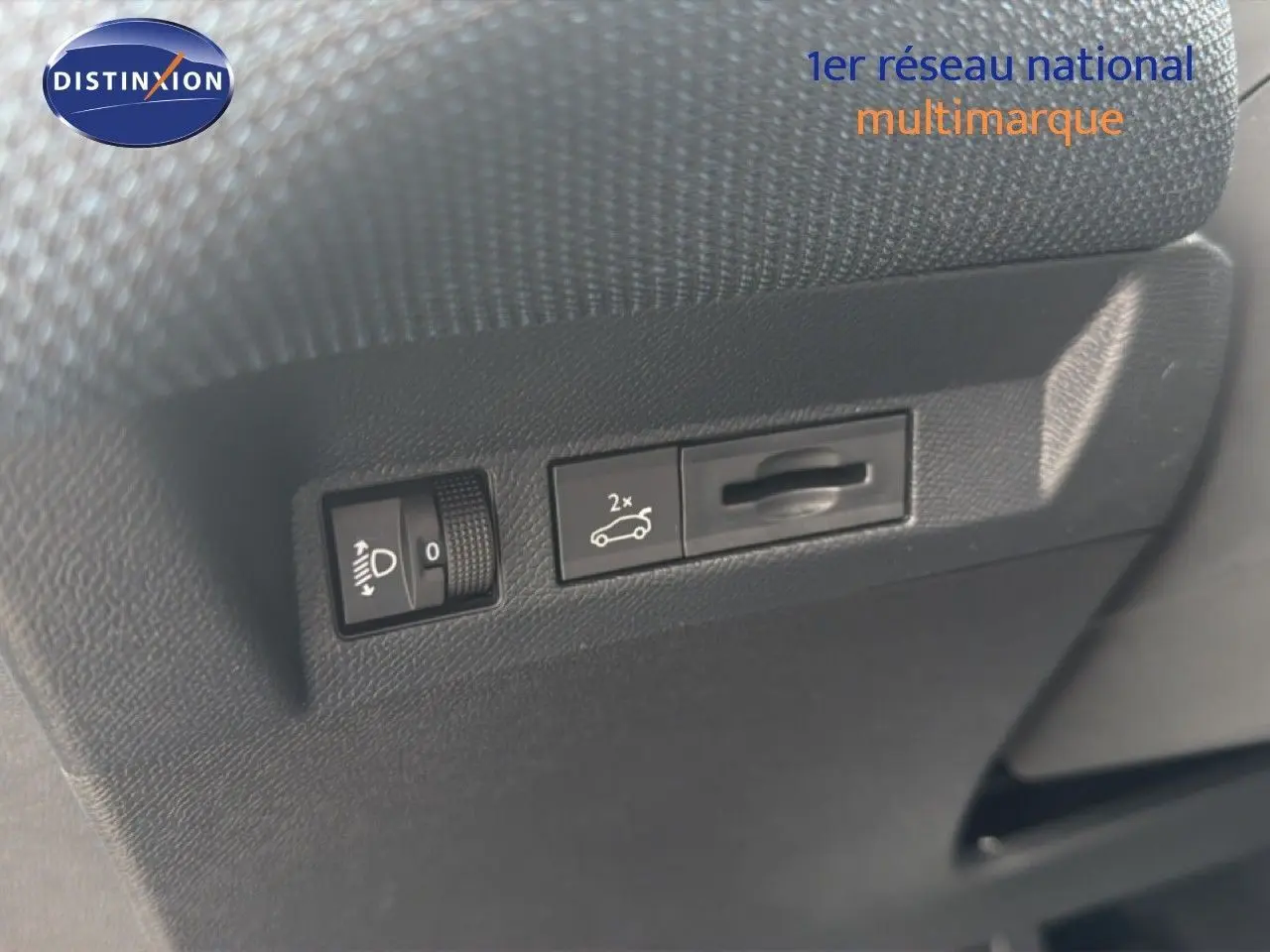 Détail des commandes d'ouverture du coffre et réglage des phares dans l'habitacle du Citroën C5 Aircross gris platinium.