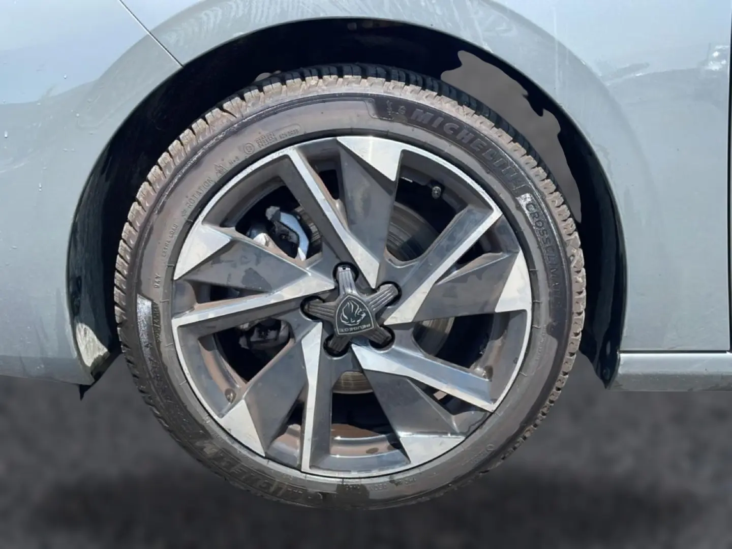 Gros plan sur la jante alu grise à design géométrique du côté gauche d’une Peugeot 308 gris 2025.
