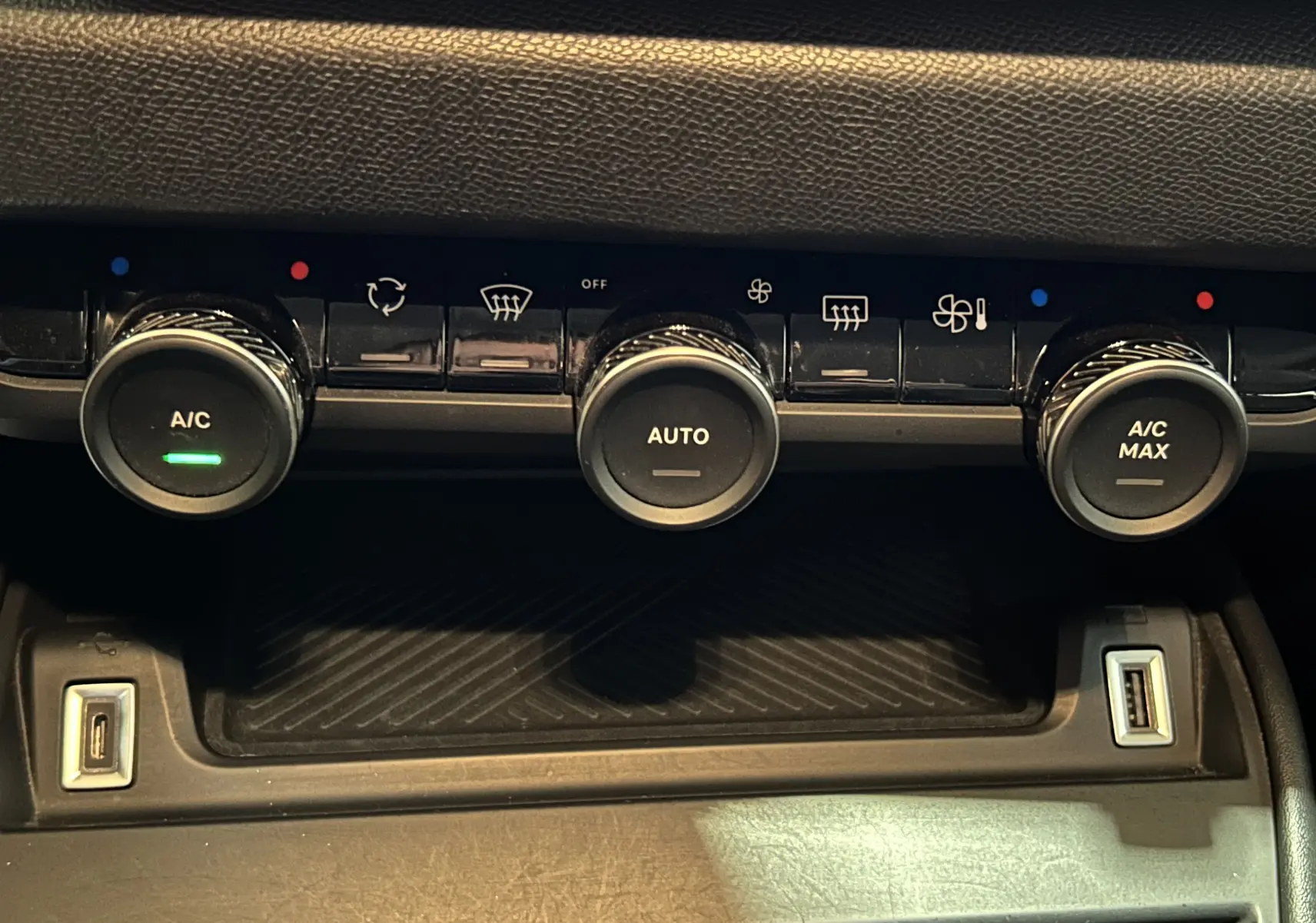 Gros plan sur la console centrale de la Citroën C4 PureTech 100 Feel 2021, avec commandes de climatisation et ports USB visibles.