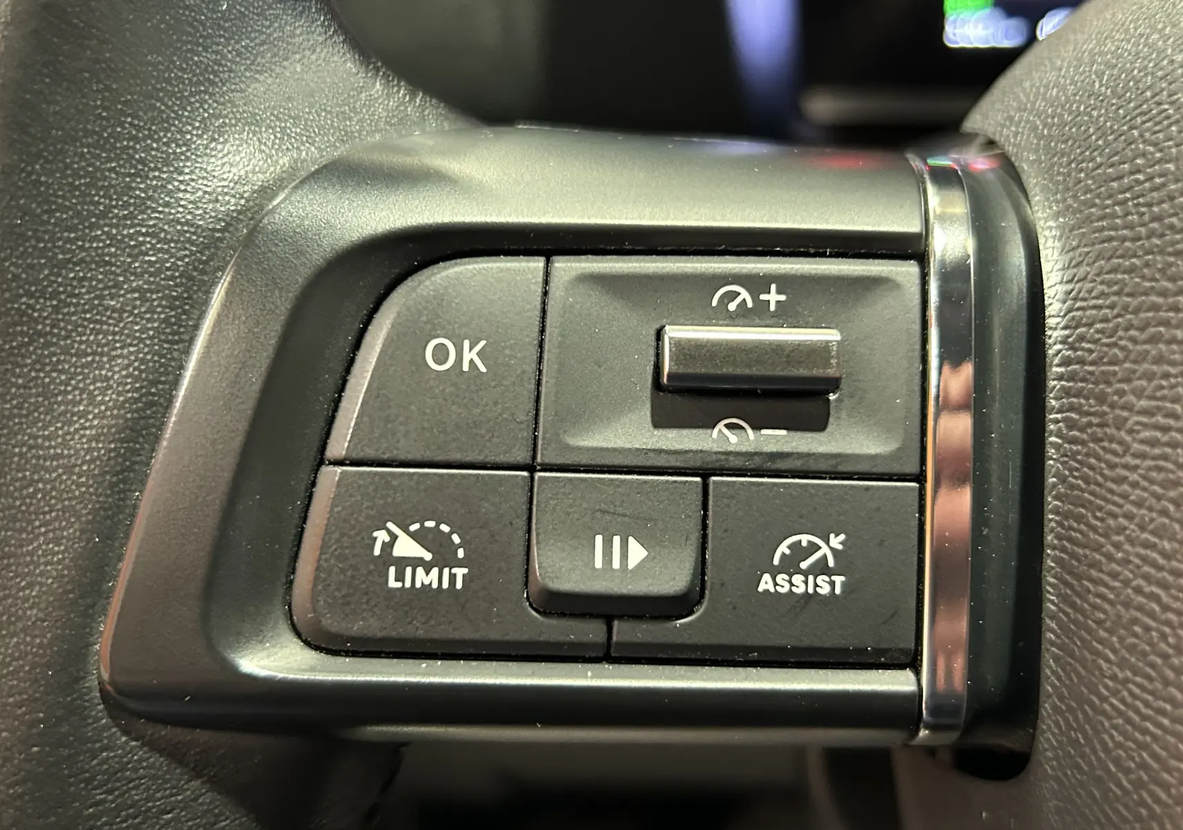 Gros plan sur les commandes au volant de la Citroën C4 PureTech 100 Feel, boutons de régulateur et limiteur de vitesse.