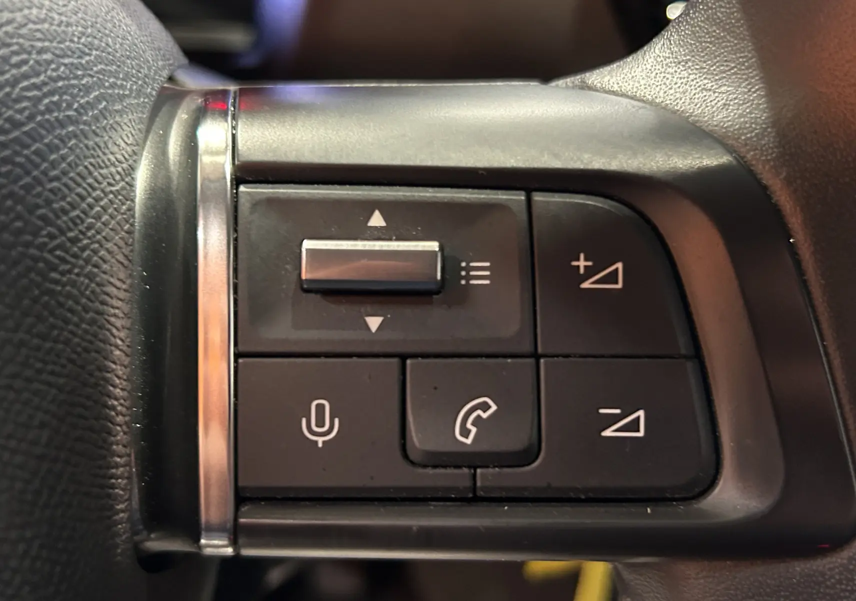 Gros plan sur les commandes au volant de la Citroën C4 PureTech 100 Feel 2021, boutons de volume et téléphone visibles.