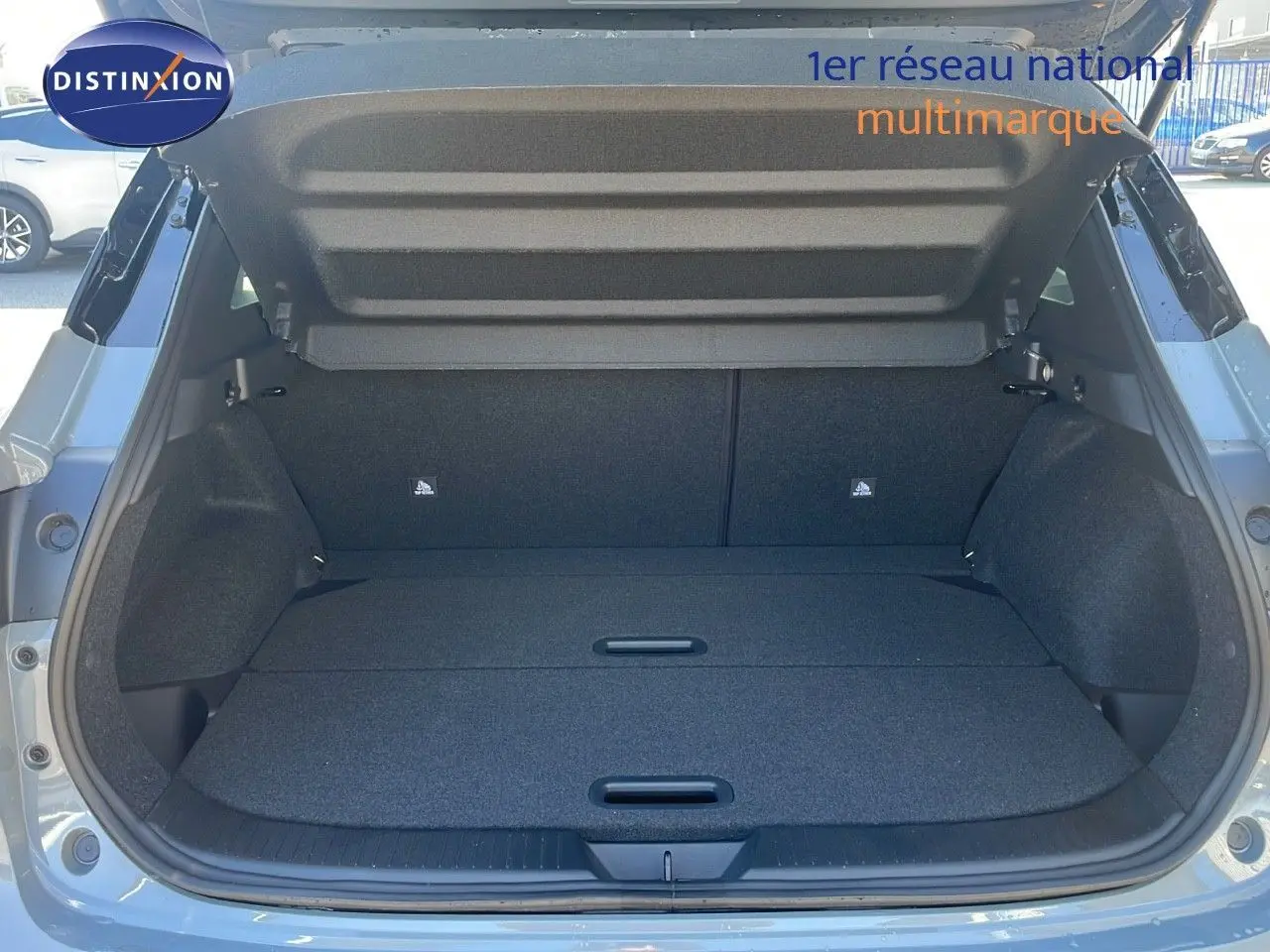 Coffre ouvert du Nissan Qashqai 2025 gris céramique métal avec toit noir, vue arrière montrant l'espace de chargement.