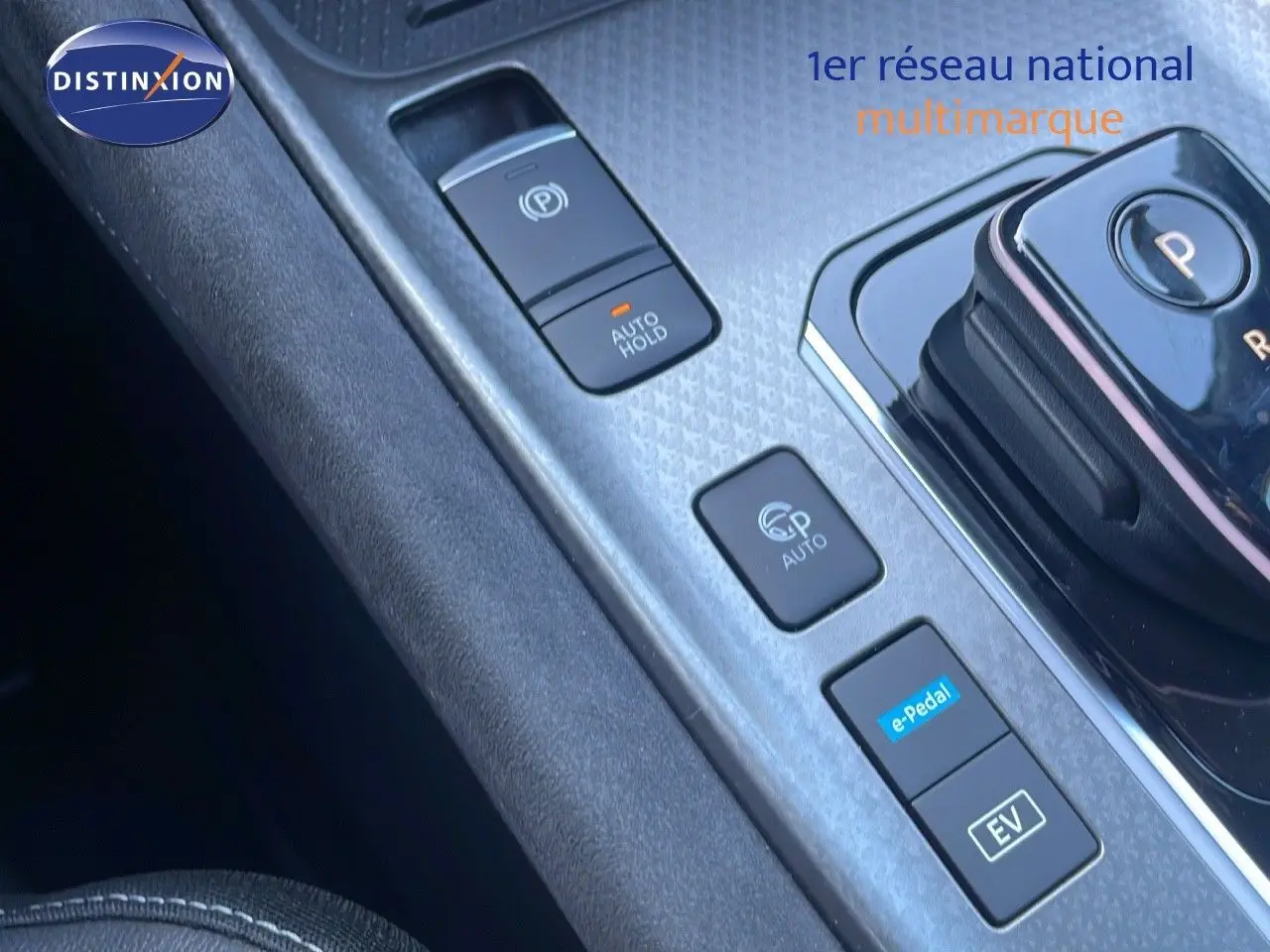 Gros plan sur la console centrale du Nissan Qashqai 2025 gris céramique, montrant les commandes de boîte auto et fonctions hybrides.