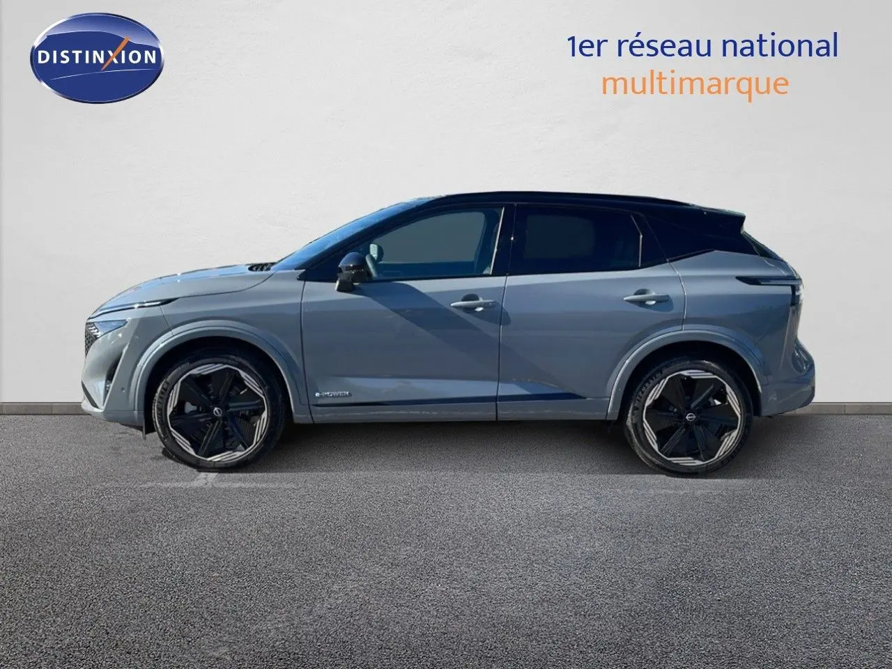 Profil gauche du Nissan Qashqai 2025 gris céramique avec toit noir et jantes noires distinctives.