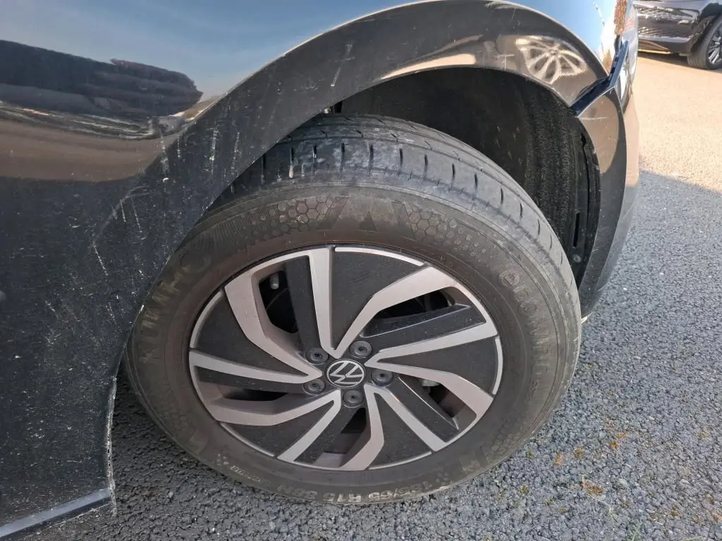 Gros plan sur la roue avant droite noire d'une Volkswagen Polo 1.0 TSI 95 DSG7 Life avec jante alliage bicolore.