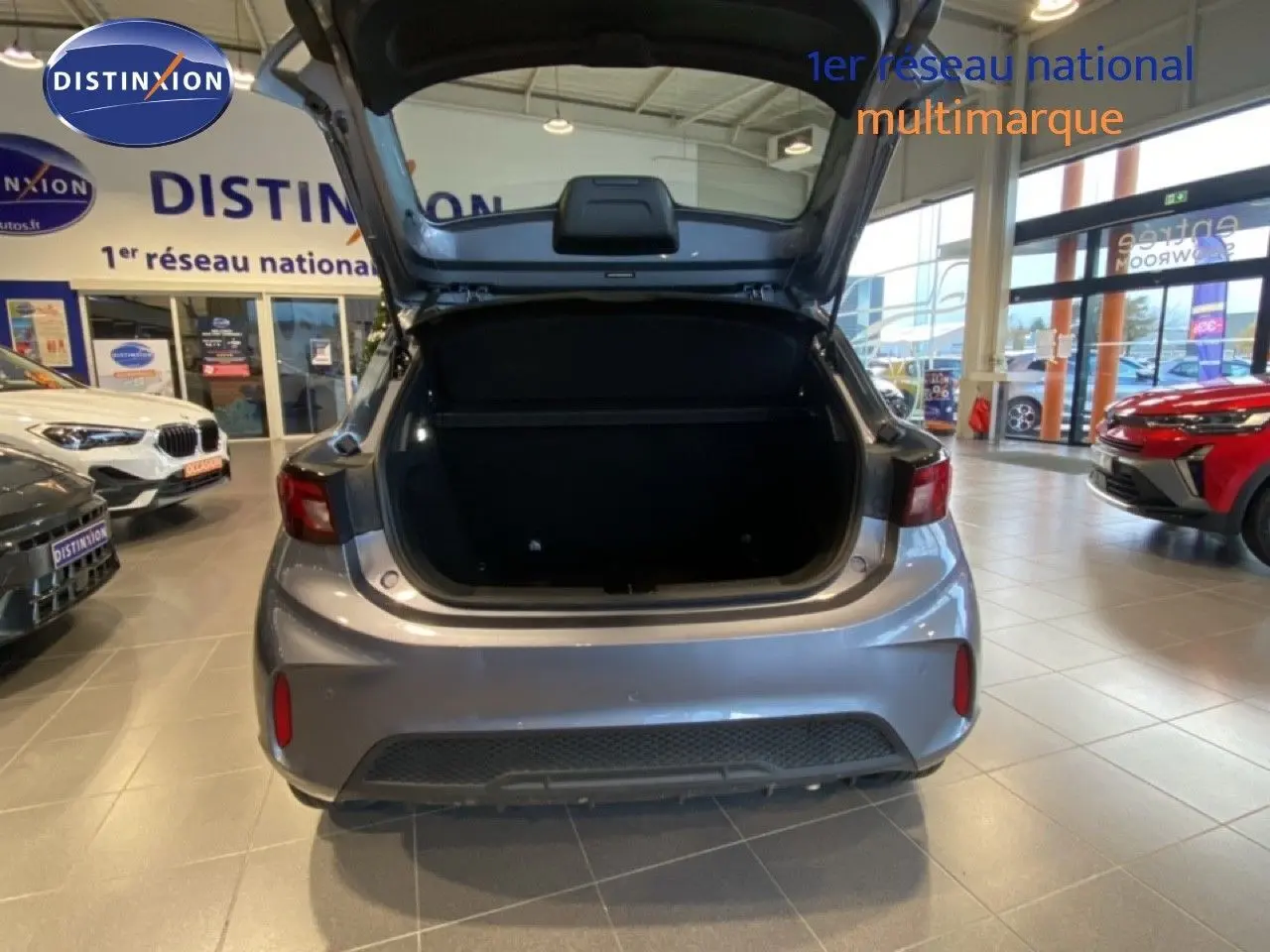 Vue arrière du MG3 1.5L HYBRID+ 195CH COMFORT en gris Hampstead, coffre ouvert dans un showroom.
