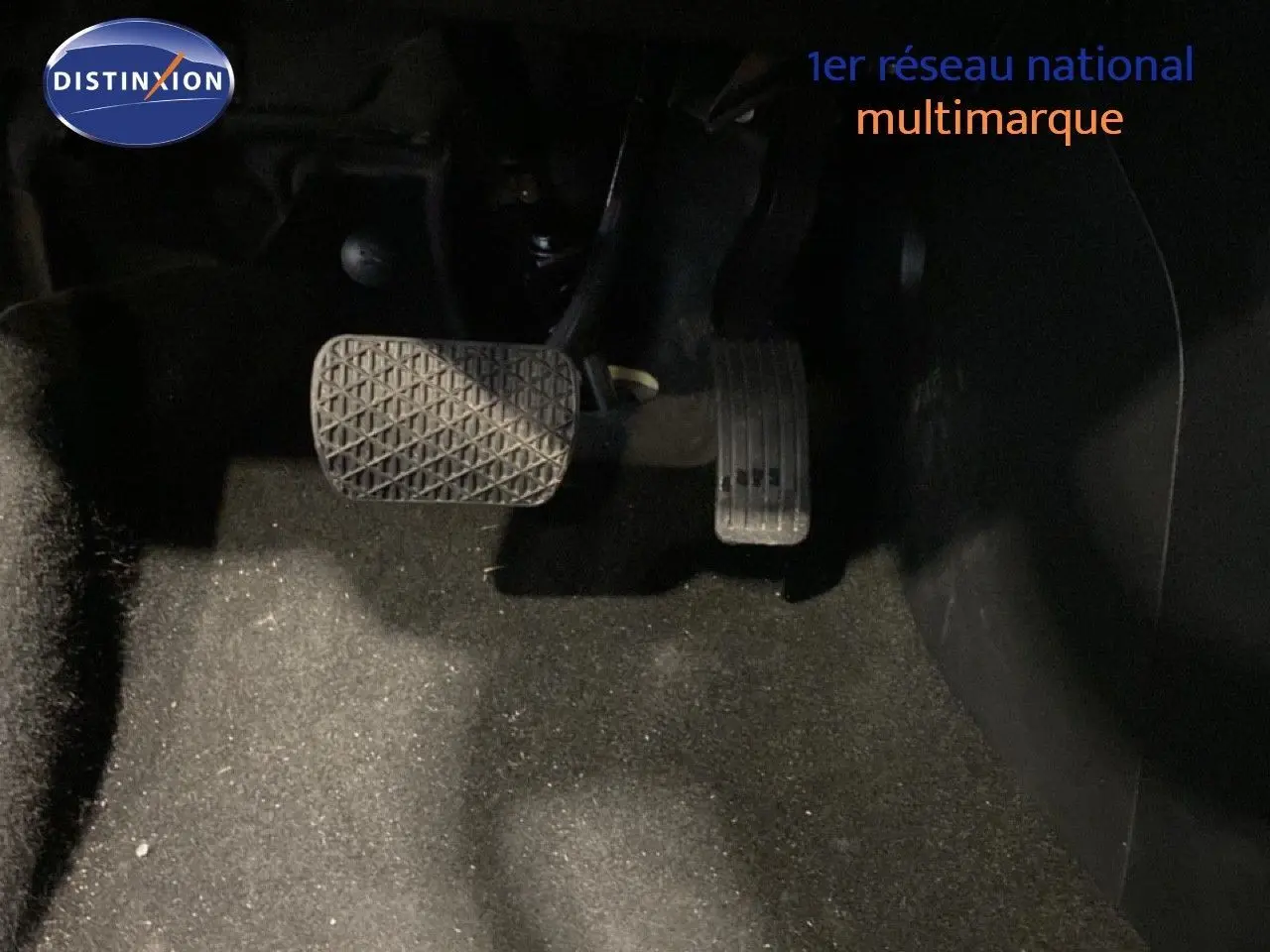 Gros plan sur les pédales d'accélérateur et de frein du MG3 1.5L Hybrid+ 2024, intérieur sombre sans détails visibles.