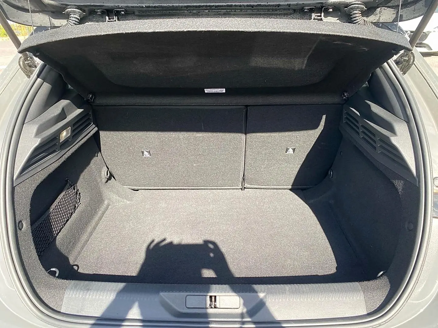 Coffre ouvert de la Peugeot 308 gris, vue de l'arrière montrant un espace de rangement propre et spacieux.