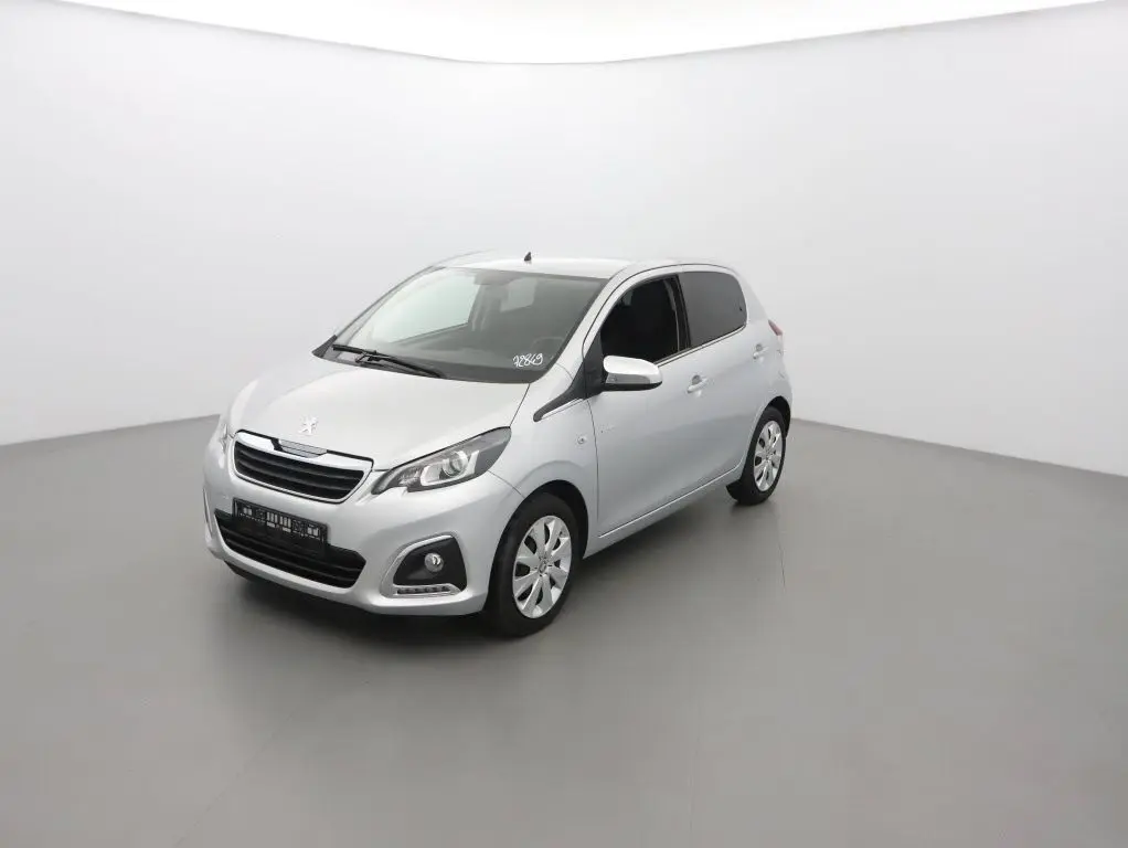 Peugeot 108 gris gallium vue 3/4 avant droit dans un studio, compacte cinq portes avec phares et calandre distinctifs.