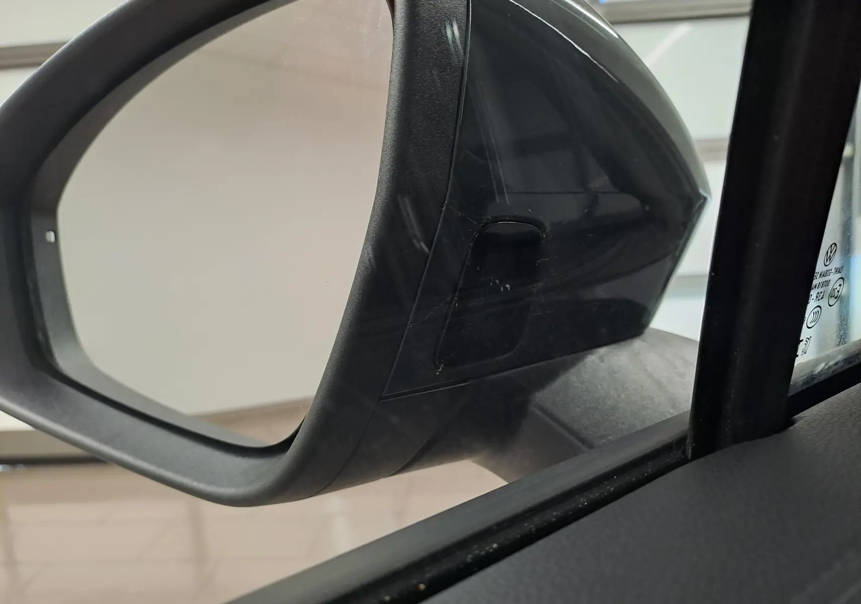 Gros plan sur le rétroviseur extérieur droit noir du Volkswagen Tiguan 2024 Gris Urano, version VW Edition Attelage.