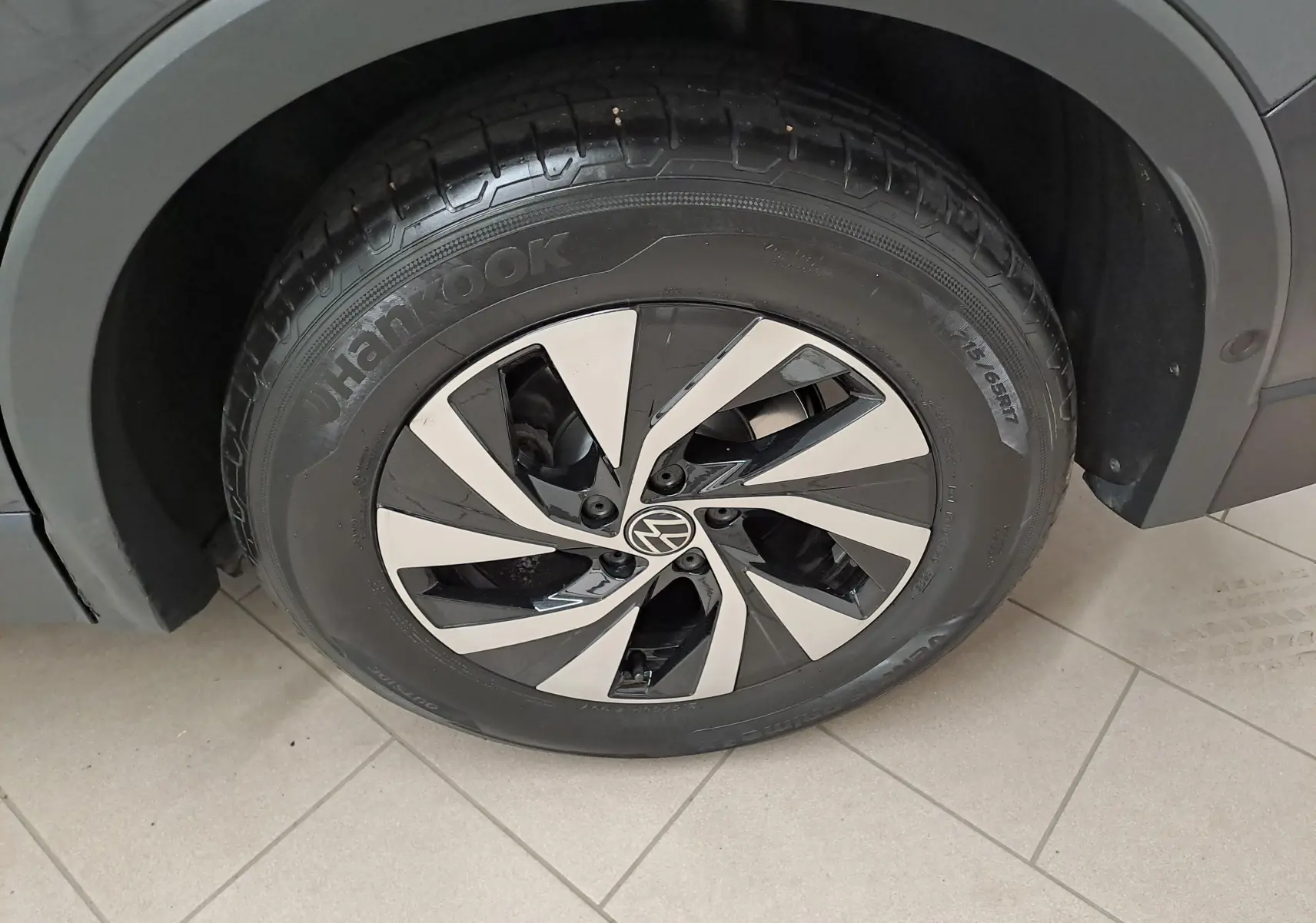 Gros plan sur la roue avant gauche du Volkswagen Tiguan 2024 gris Urano avec jante alliage bicolore et pneu Hankook.