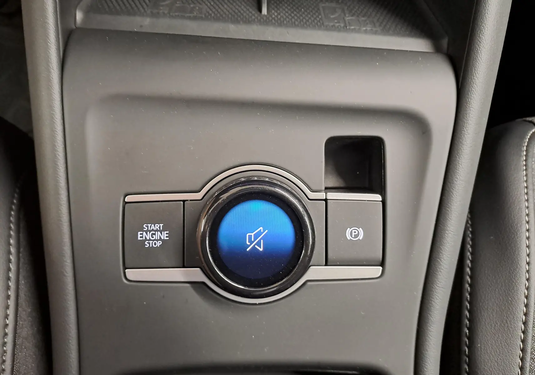 Gros plan sur la commande centrale noire du Volkswagen Tiguan 2024 avec bouton start/stop et frein à main électronique.