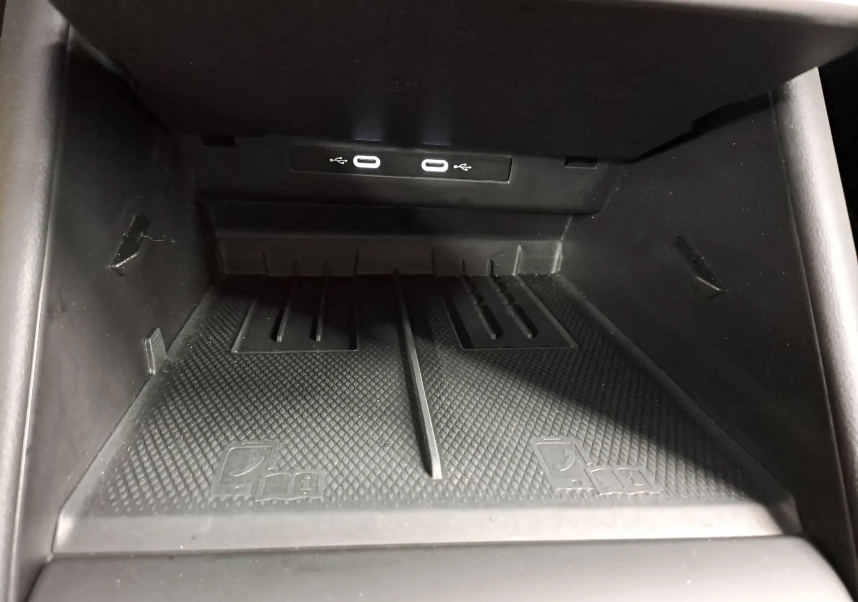 Gros plan sur la zone de chargement sans fil avec deux ports USB-C éclairés à l'avant d'un Volkswagen Tiguan Gris Urano 2024.