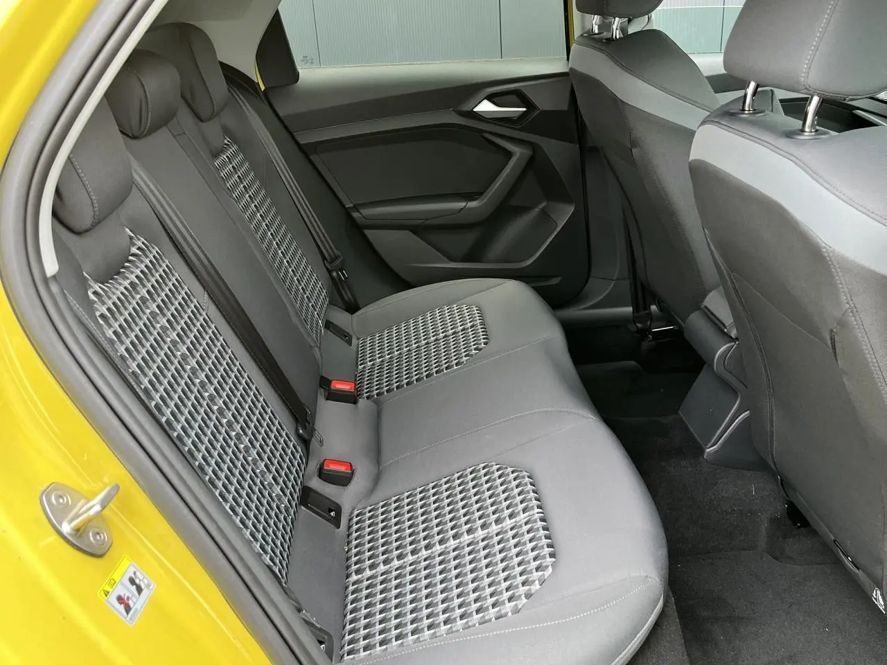 Vue intérieure arrière droite des sièges arrière gris à motifs de l'Audi A1 Allstreet jaune Python.