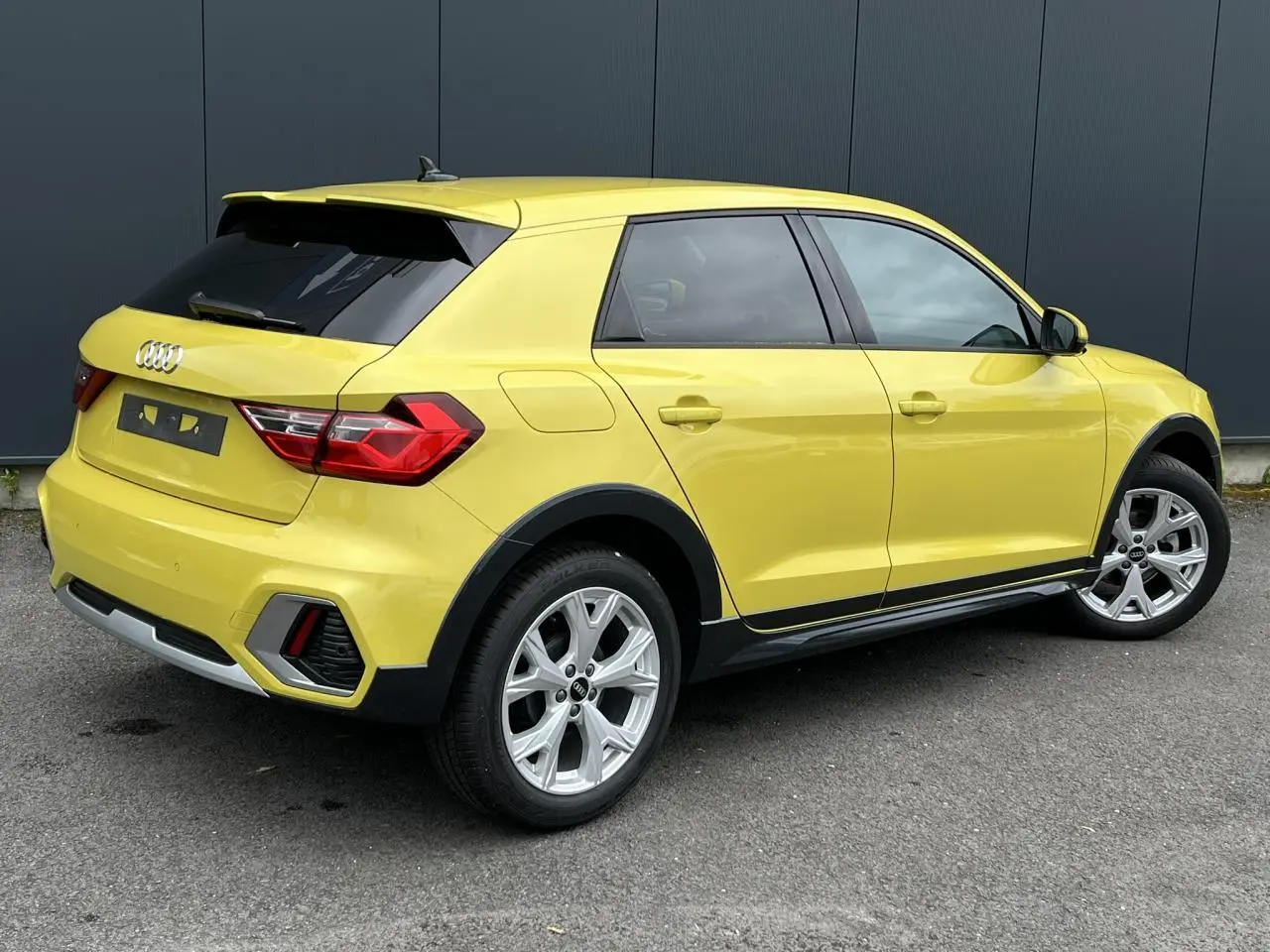Audi A1 Allstreet jaune Python vue 3/4 arrière droit, avec jantes alu 5 branches et vitres arrière surteintées.