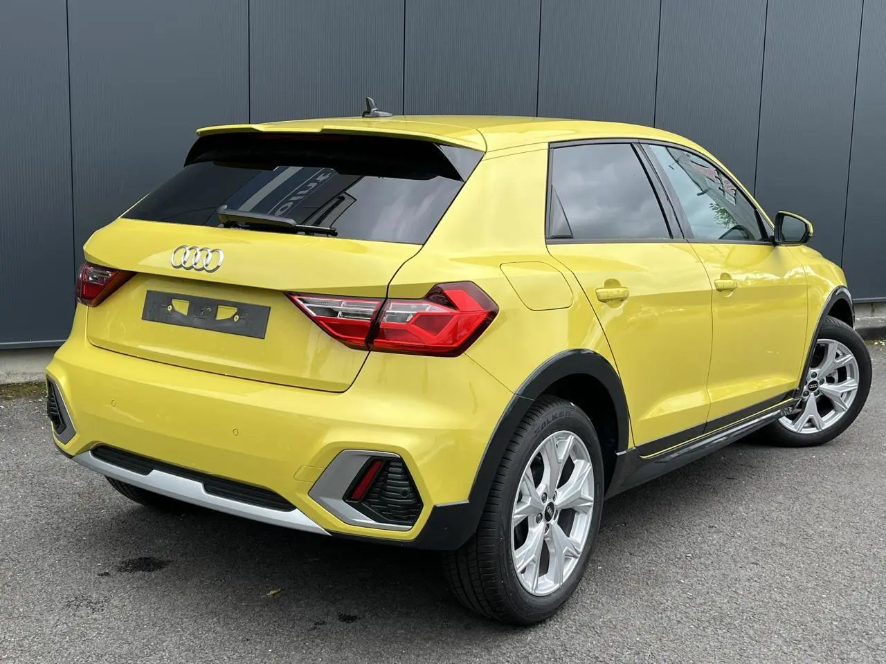 Audi A1 Allstreet jaune Python vue 3/4 arrière droit, avec jantes alu 5 branches en Y et vitres arrière surteintées.