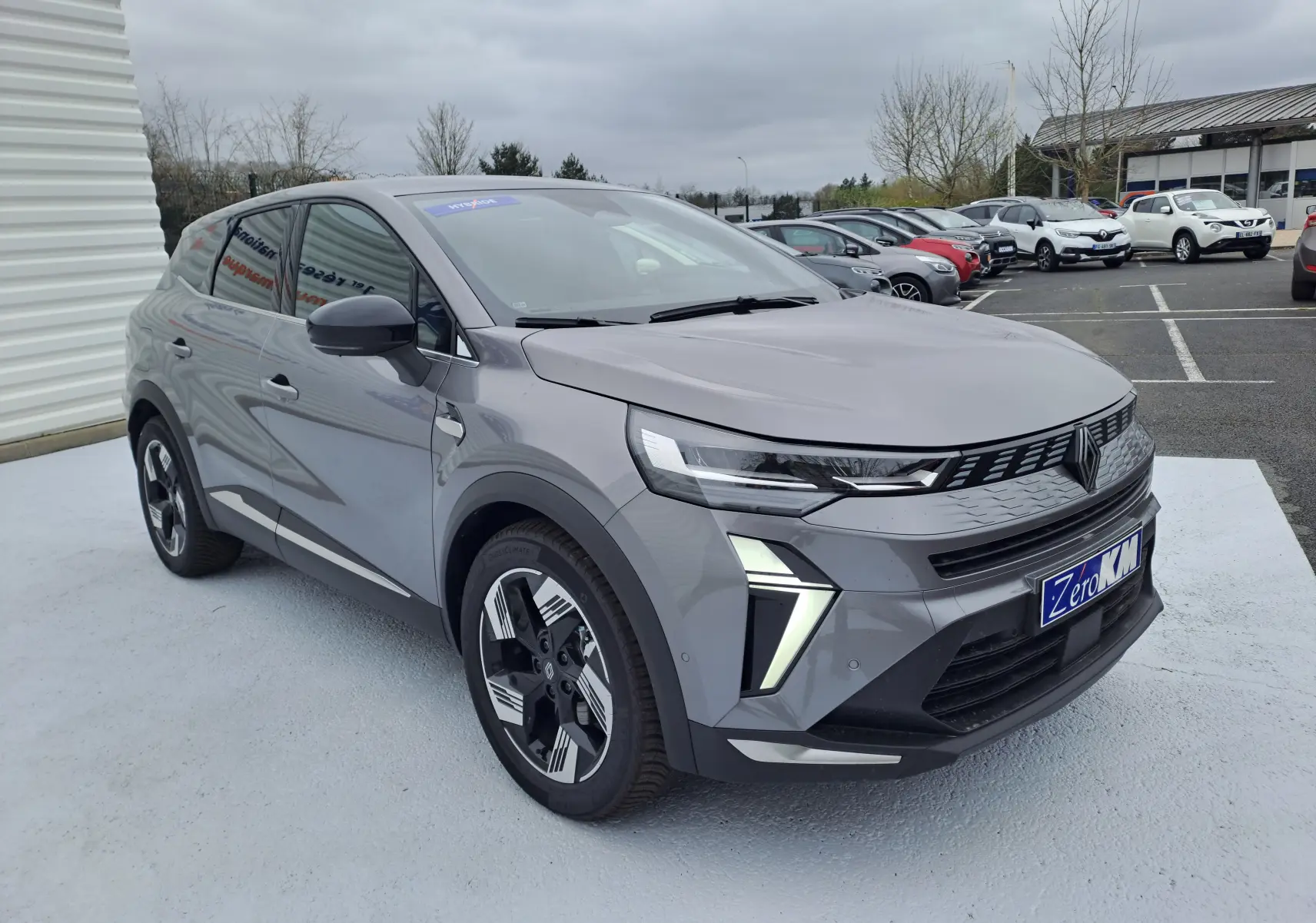 Renault Symbioz gris Cassiope en 3/4 avant droit, avec feux LED distinctifs et jantes alliage bicolores.