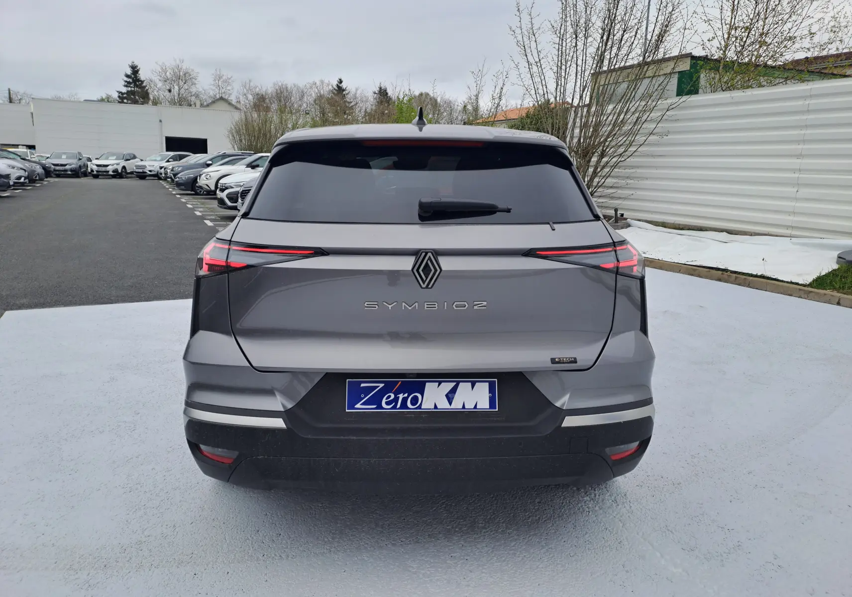 Vue arrière d'une Renault Symbioz gris Cassiope avec feux arrière LED fins et plaque d'immatriculation Zero KM visible