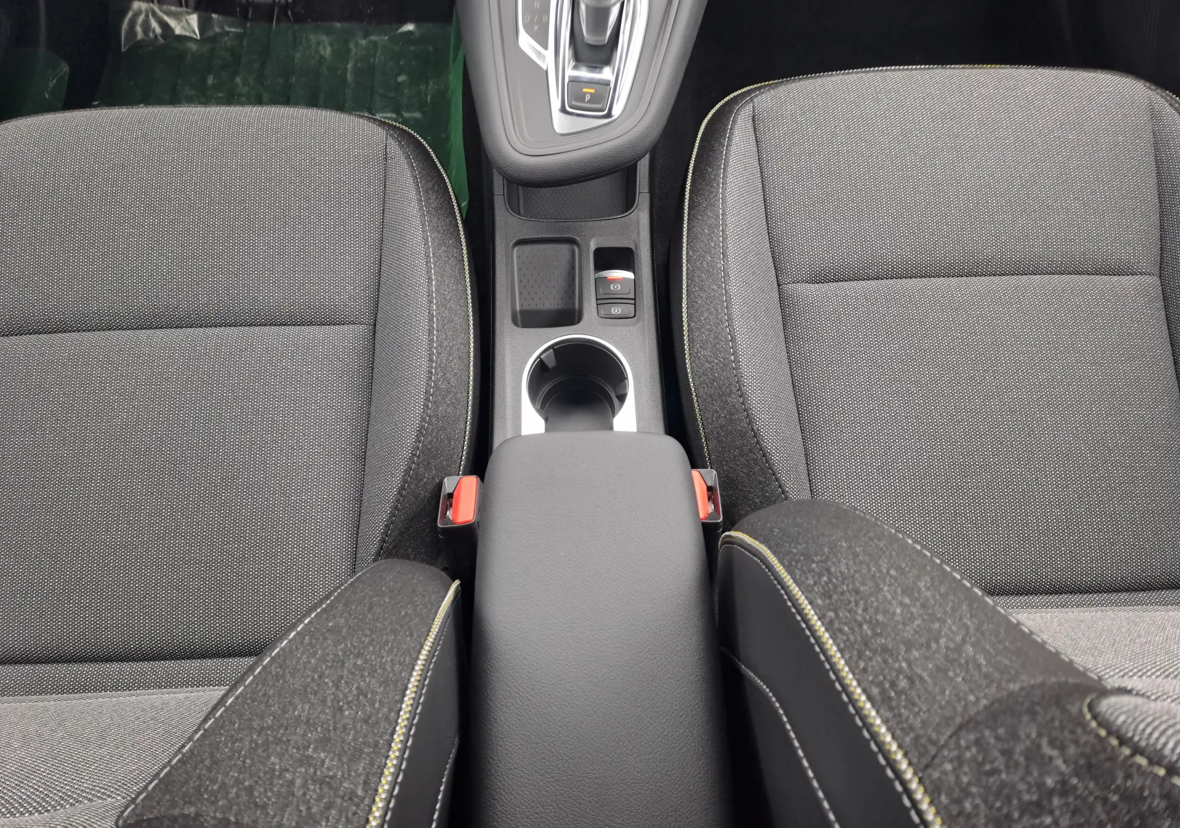 Vue plongeante sur la console centrale et sièges avant en tissu gris foncé de la Renault Symbioz 2024.