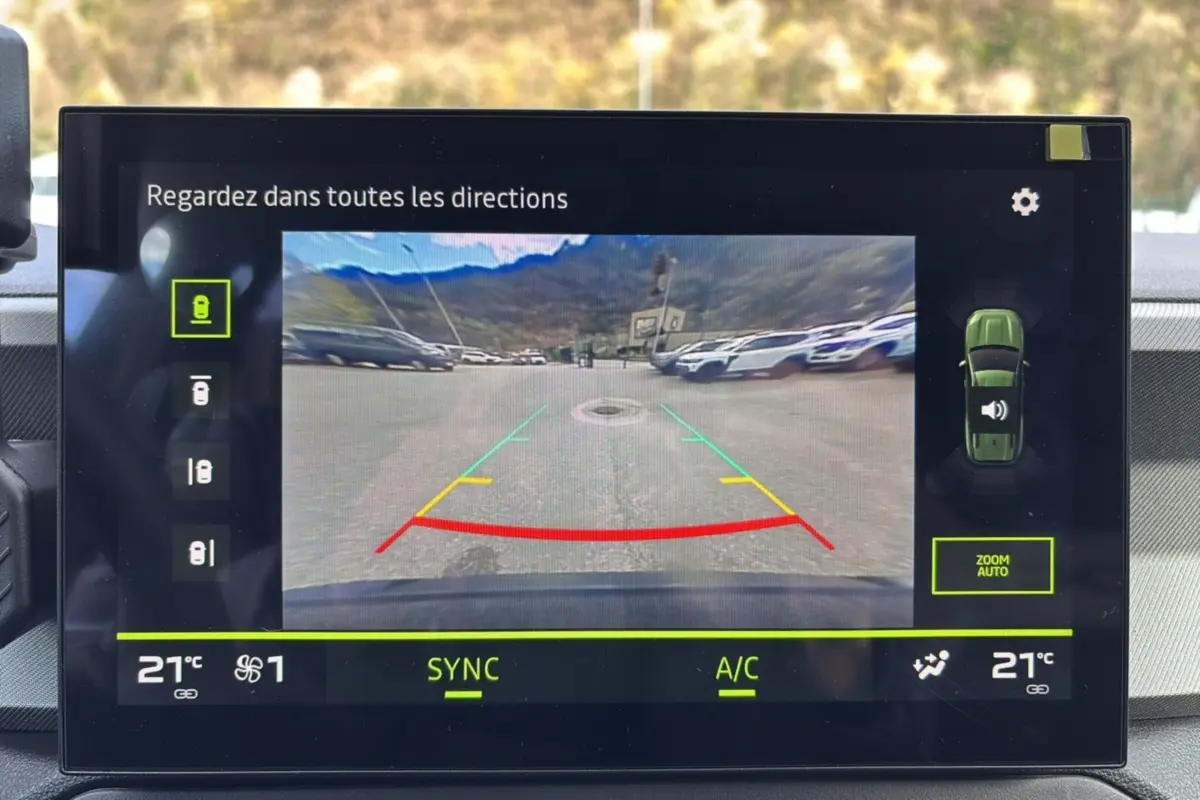 Écran tactile du système multimédia montrant la caméra multiview arrière du Dacia Bigster bleu indigo avec toit noir.