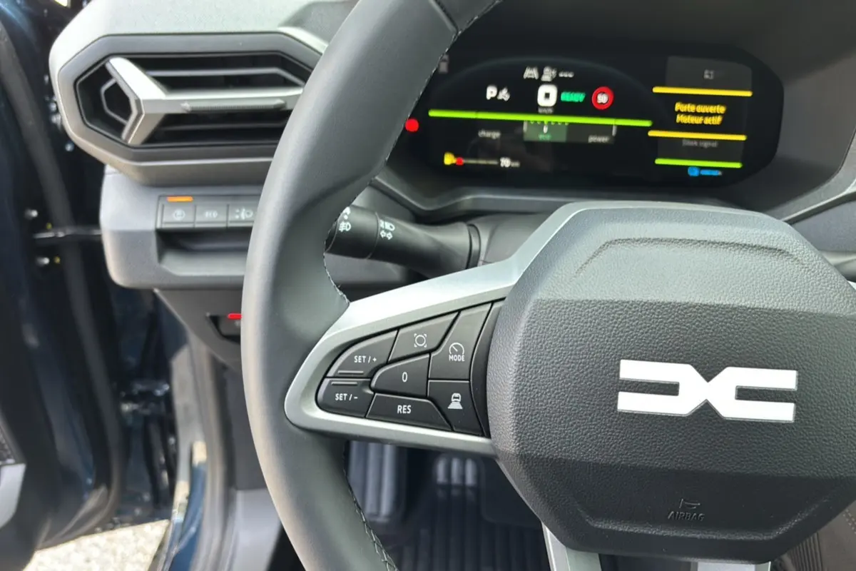 Gros plan sur le volant cuir et le tableau de bord digital du Dacia Bigster Hybrid 155, intérieur en bleu indigo.