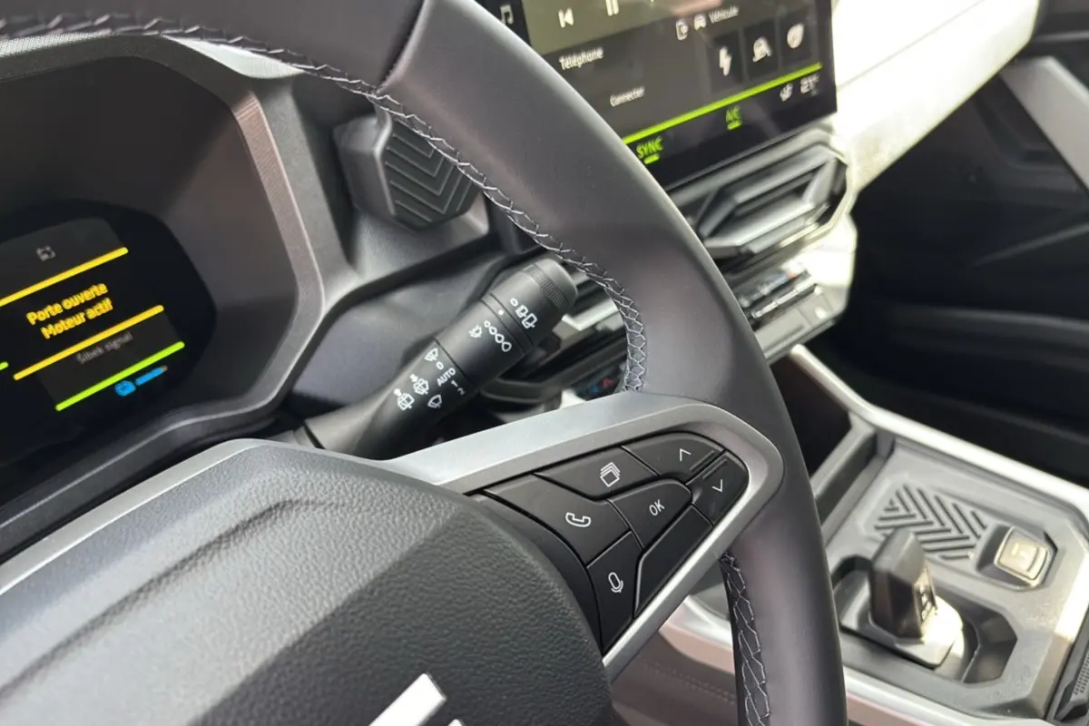 Gros plan sur le volant cuir et commandes multifonctions du tableau de bord digital du Dacia Bigster Hybrid 155 Journey Plus.