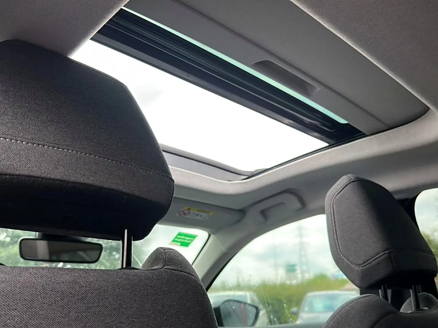 Vue intérieure arrière montrant les appuis-tête et le toit ouvrant du Citroën C4 gris 2024.