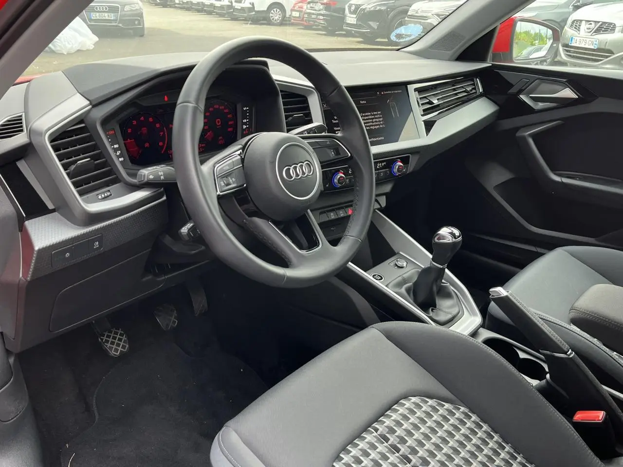 Intérieur de l'Audi A1 Sportback 2022 vu côté conducteur, volant cuir multifonctions et levier de vitesses manuel.