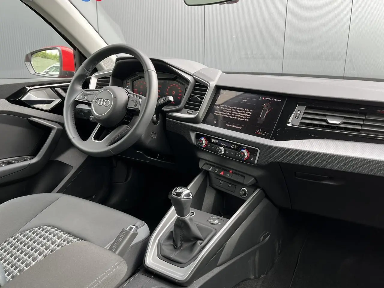 Intérieur Audi A1 Sportback 2022 vu côté conducteur, volant cuir 3 branches et levier de vitesse manuel visible.