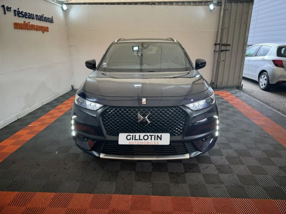 Vue frontale d'un DS7 Crossback E-TENSE 4x4 bleu avec calandre distinctive et feux LED allumés en intérieur.