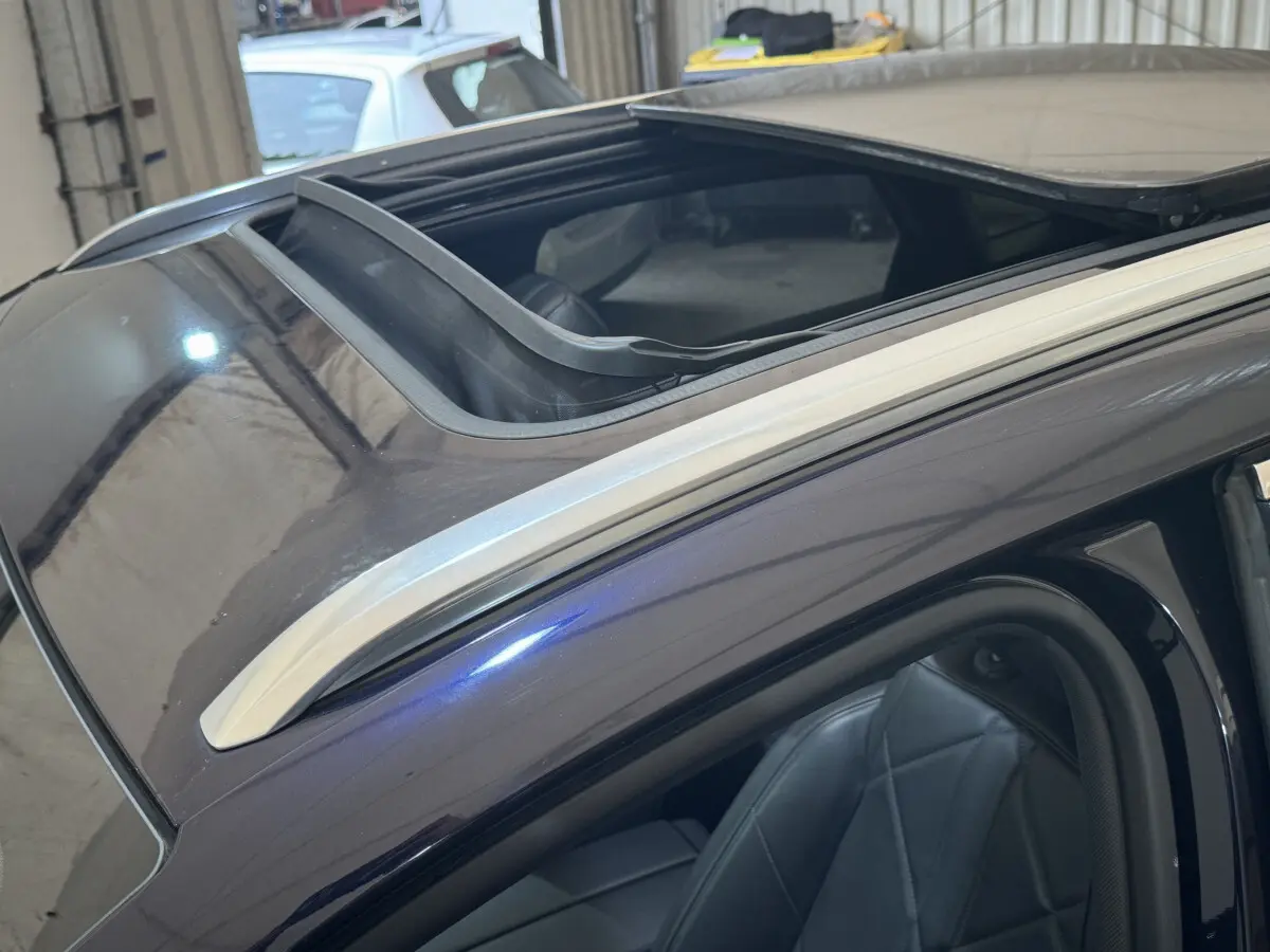 Vue rapprochée du toit ouvrant panoramique et du siège avant en cuir du DS7 Crossback E-TENSE bleu.