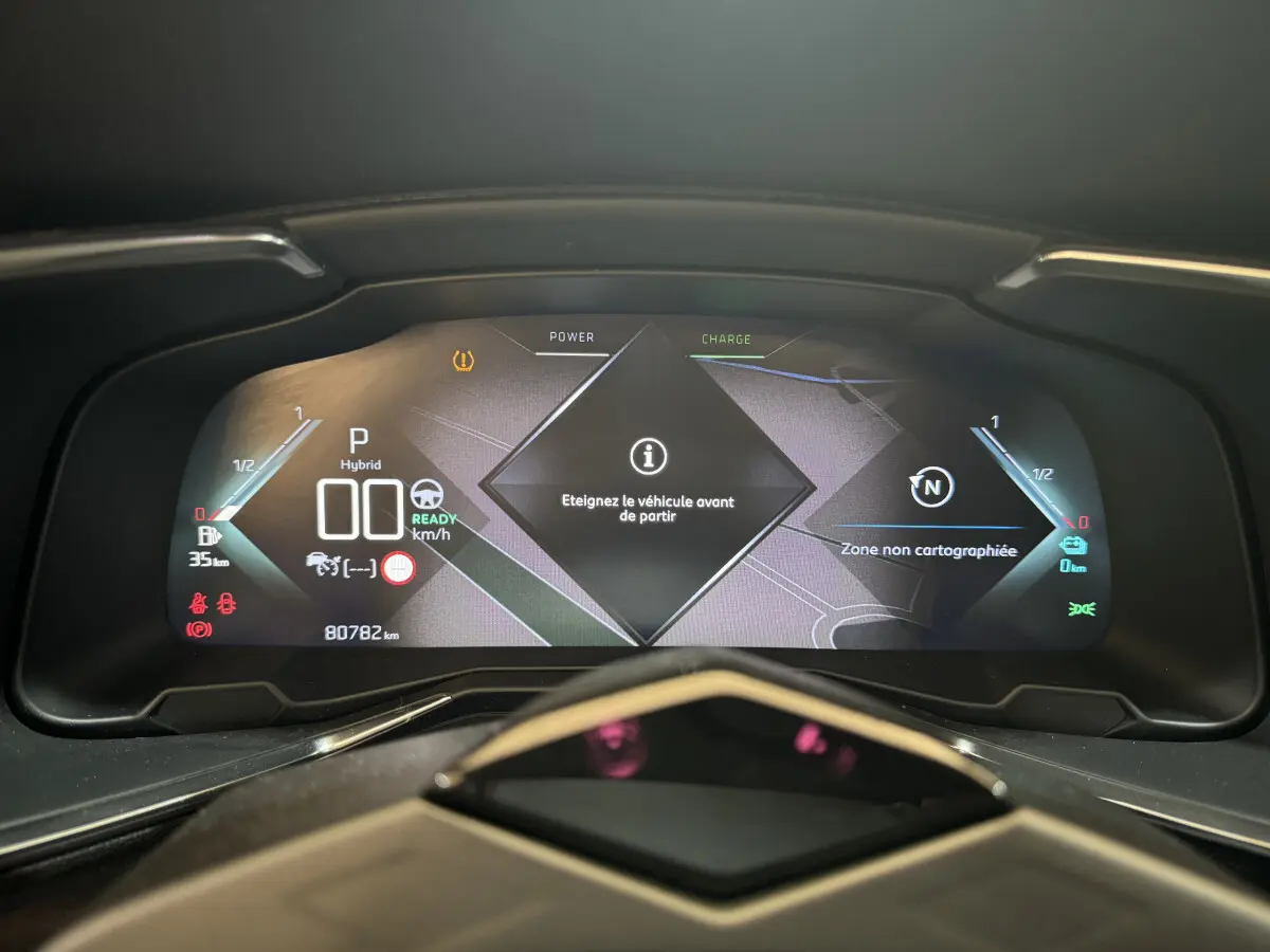 Tableau de bord numérique du DS7 Crossback E-TENSE 4x4 affichant informations hybrides et avertissements.