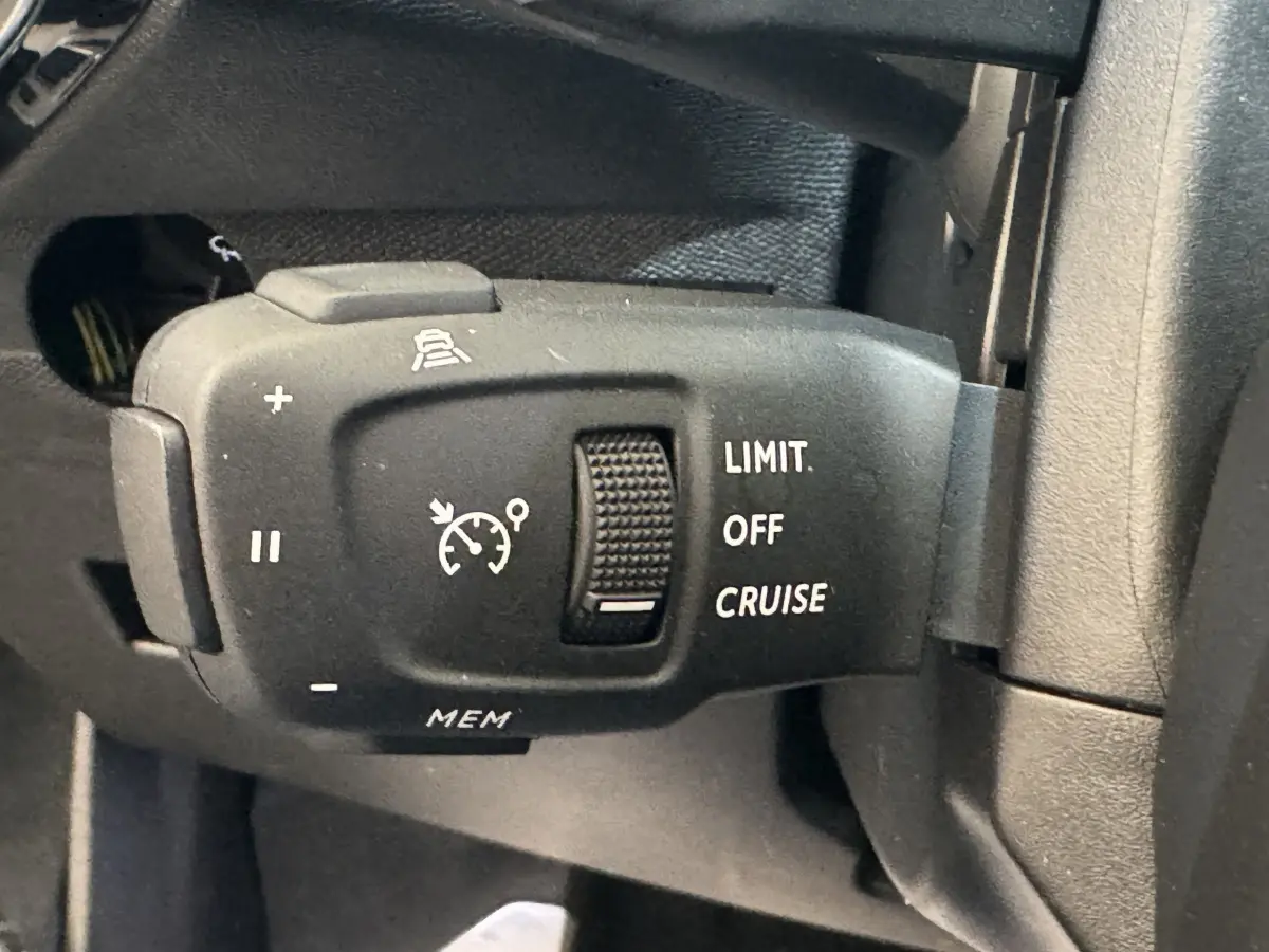 Gros plan sur la commande de régulateur de vitesse noir mat à gauche du volant du DS7 Crossback bleu E-TENSE 2020