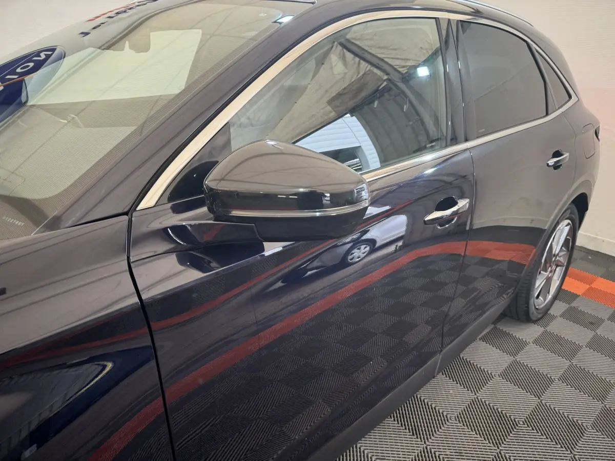 Vue latérale droite du DS7 Crossback E-TENSE bleu, mettant en valeur la portière et le rétroviseur noir brillant.
