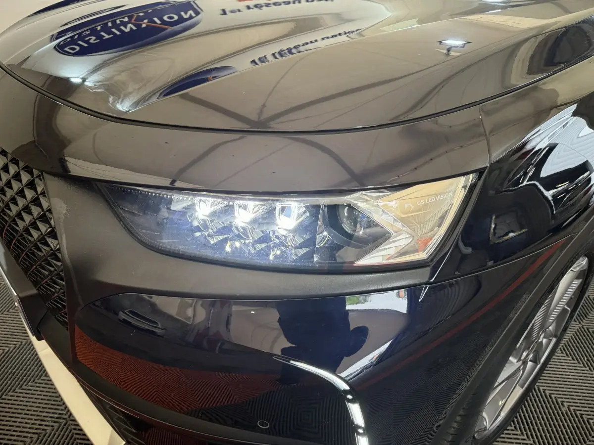 Gros plan sur le phare avant droit bleu du DS7 Crossback E-TENSE 4x4 avec signature lumineuse LED distinctive.