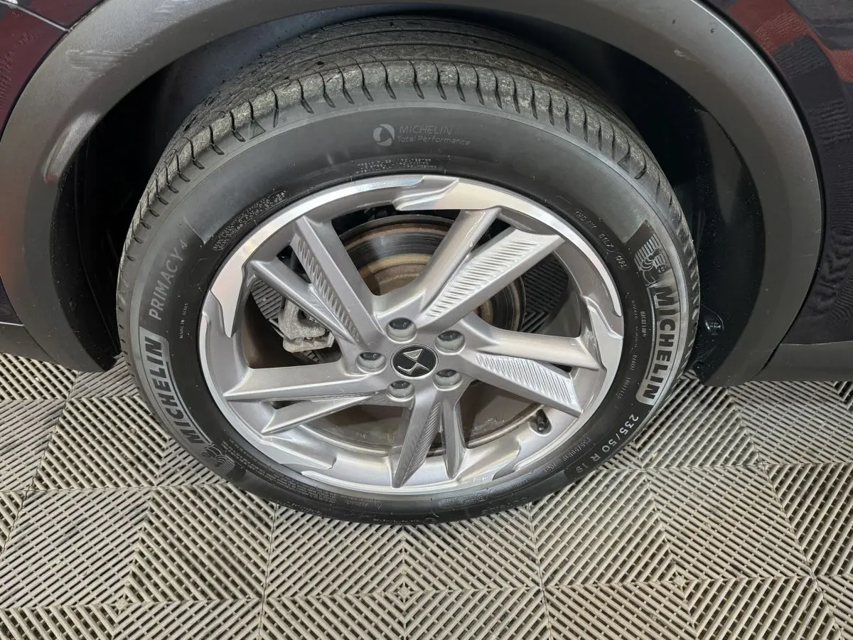 Gros plan sur la roue avant droite du DS7 Crossback E-TENSE bleu, avec jante alliage et pneu Michelin Primacy 4.
