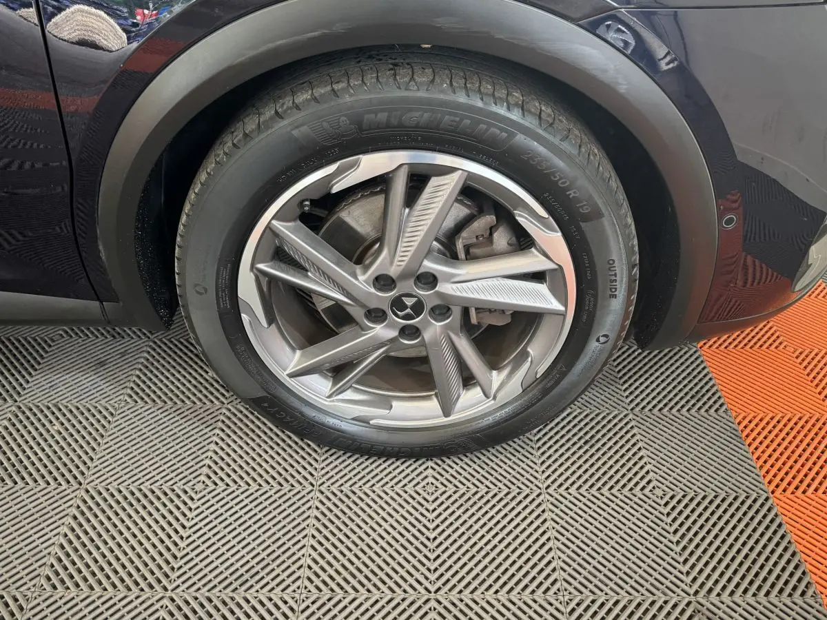 Gros plan sur la roue avant gauche bleu foncé du DS7 Crossback E-TENSE 4x4 avec jante alliage à cinq branches doubles.