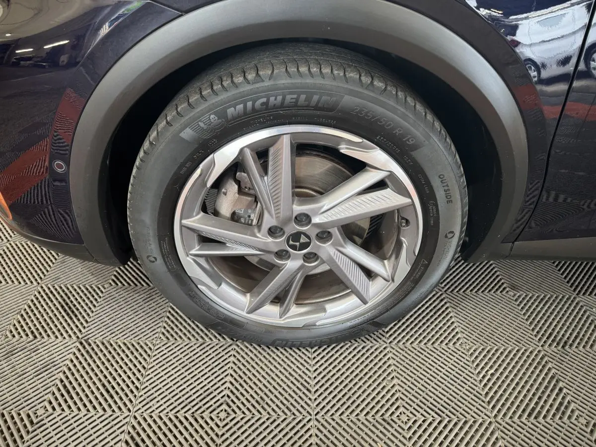 Gros plan sur la roue avant gauche bleue du DS7 Crossback E-TENSE 4x4 avec jante alliage et pneu Michelin.