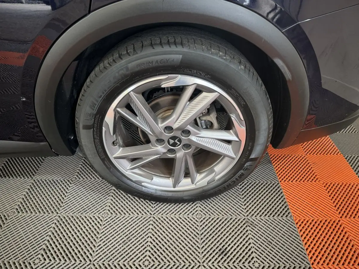 Gros plan sur la roue avant gauche bleu foncé du DS7 Crossback E-TENSE avec jante alliage au design moderne.