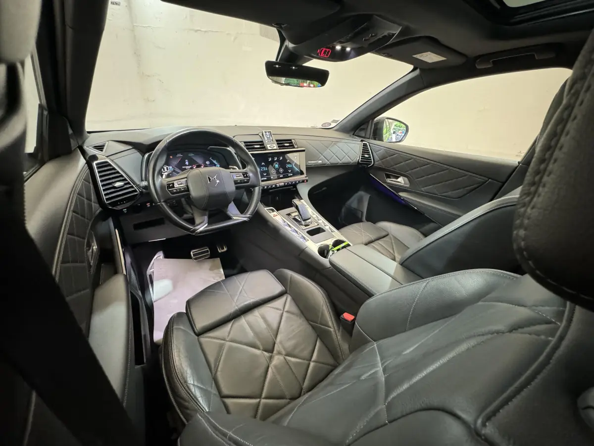 Intérieur cuir noir du DS7 Crossback E-TENSE 4x4 Grand Chic vu côté conducteur, tableau de bord et écran tactile visibles.