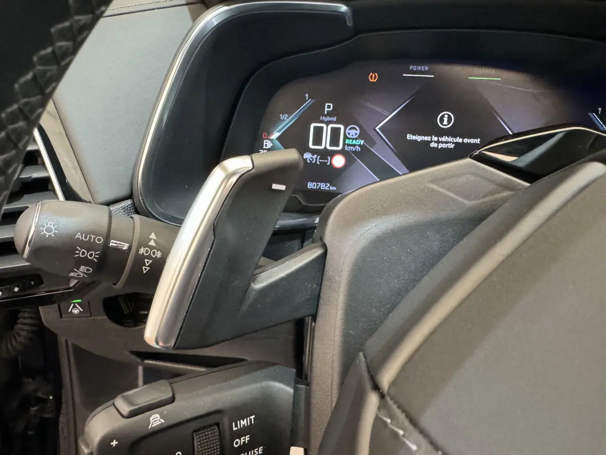 Gros plan sur le levier de vitesses et le tableau de bord numérique du DS7 Crossback E-TENSE bleu, affichage hybride et 80 782 km.