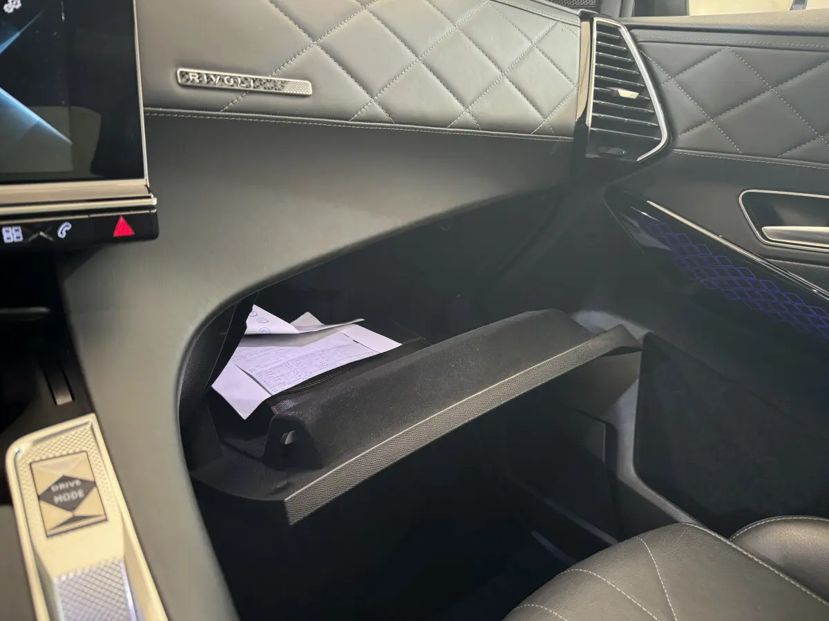 Intérieur du DS7 Crossback E-TENSE 4x4 Grand Chic 2020, vue sur boîte à gants ouverte et tableau de bord cuir noir matelassé.
