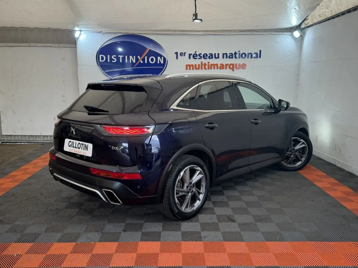Vue 3/4 arrière droite du DS7 Crossback E-TENSE bleu, avec feux LED et double sortie d'échappement chromée.