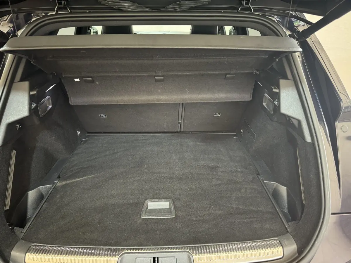 Coffre ouvert du DS7 Crossback E-TENSE bleu, montrant l'espace de chargement et la tablette arrière noire.